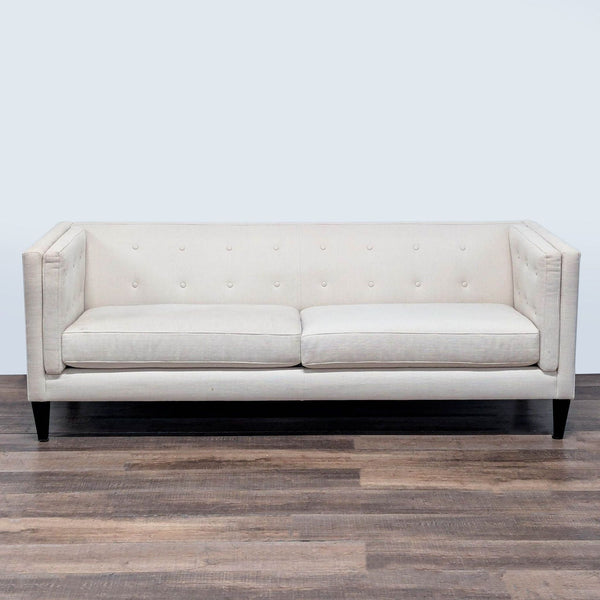 1. Crate and Barrel 3-seat sofa with tuxedo frame, button-tufted back, and tapered wood feet, shown from the front.