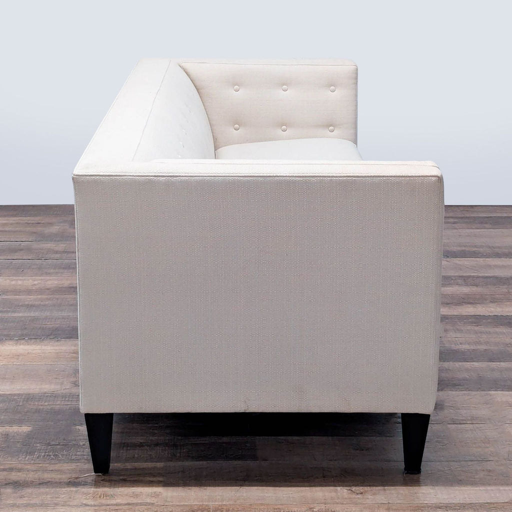 2. Side view of trim Crate and Barrel 3-seat sofa, highlighting Euro-style interior bolsters and tapered conical legs.