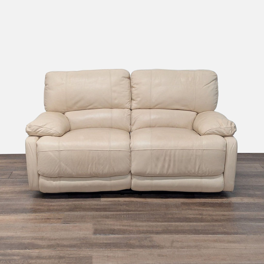 1. Front view of Reperch Loveseat with beige leather upholstery and dual reclining seats on a wood floor.