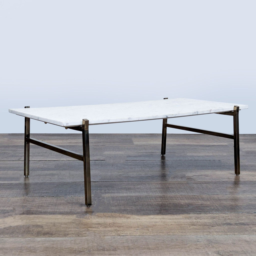 2. Modern CB2 coffee table, featuring a white marble surface and metal frame base, angled side view.