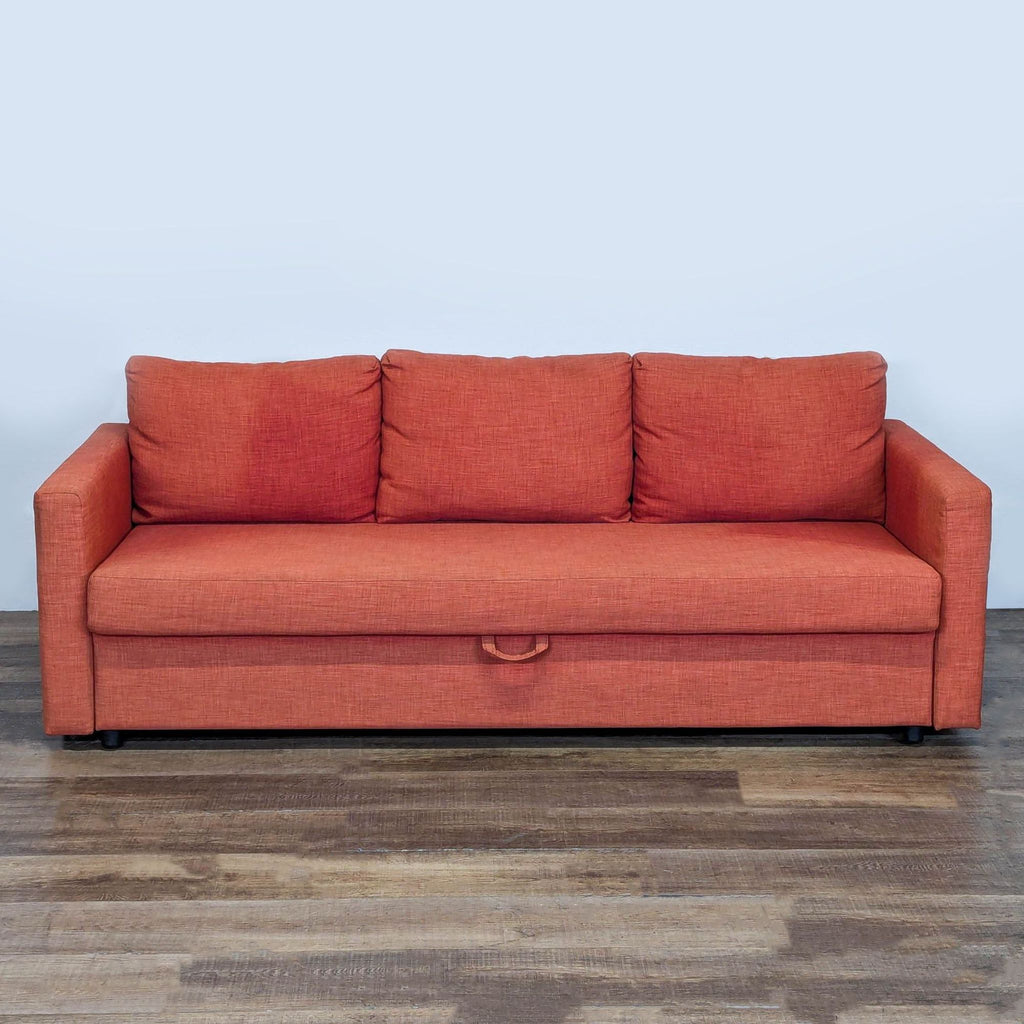 1. Orange 3-seat Ikea sofa with pull-out sleeper and under-seat storage, shown on a wooden floor.