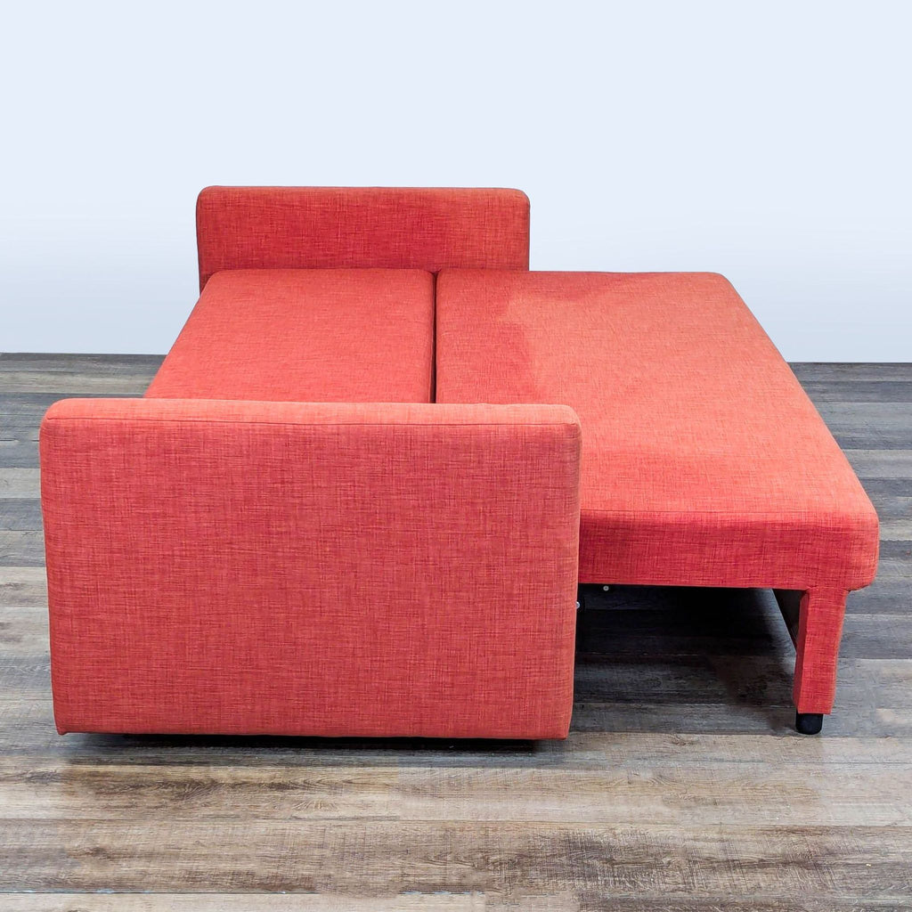 2. Ikea orange sofa bed extended into sleeping position, illustrating its pull-out sleeper function.