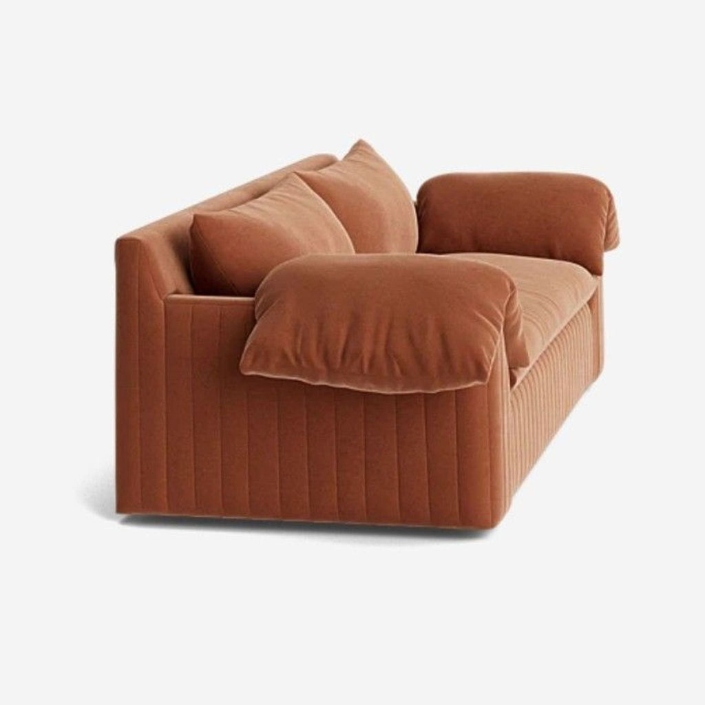 Side view of Lulu and Georgia’s rose velvet loveseat, showing plush bench seat and channel tufted base.