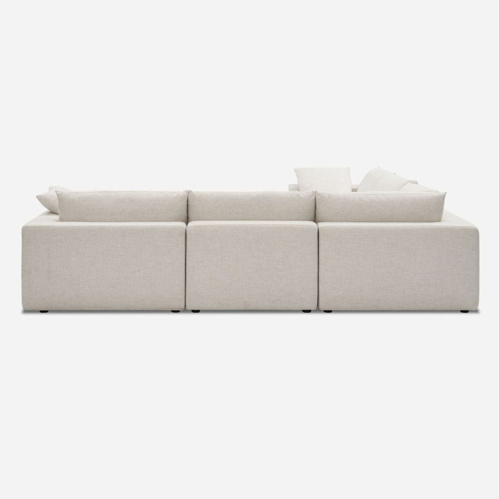 3. Rear view of a Castlery sectional featuring Beach Linen Upholstery and plush, feather-filled back cushions.
