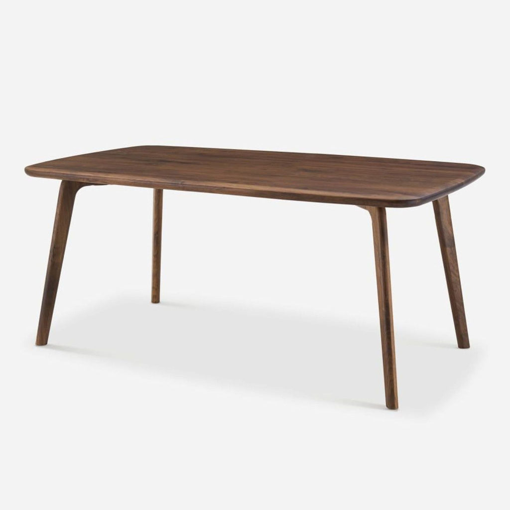 2. Angled view of a Castlery dining table, made of solid American walnut, with a smooth finish.