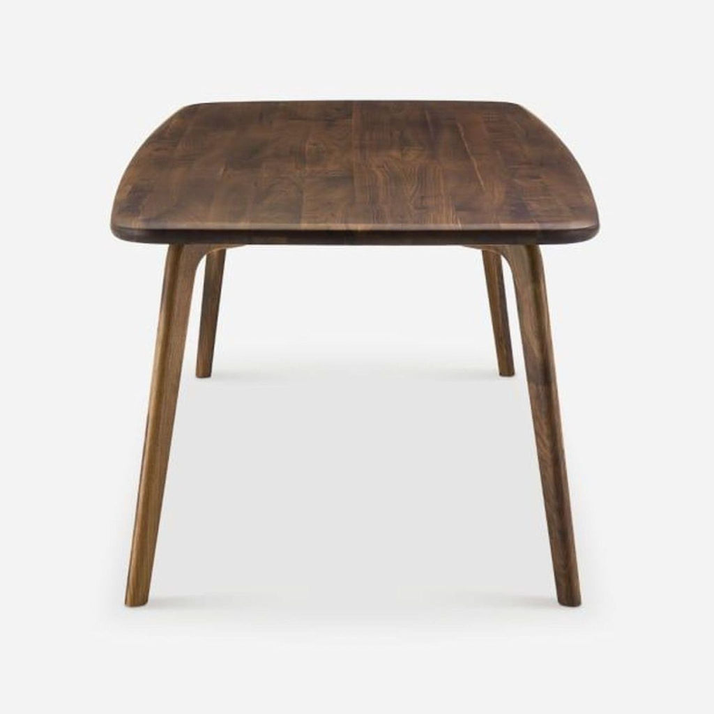 3. Solid American walnut Castlery dining table viewed from the short end, showing sturdy legs.