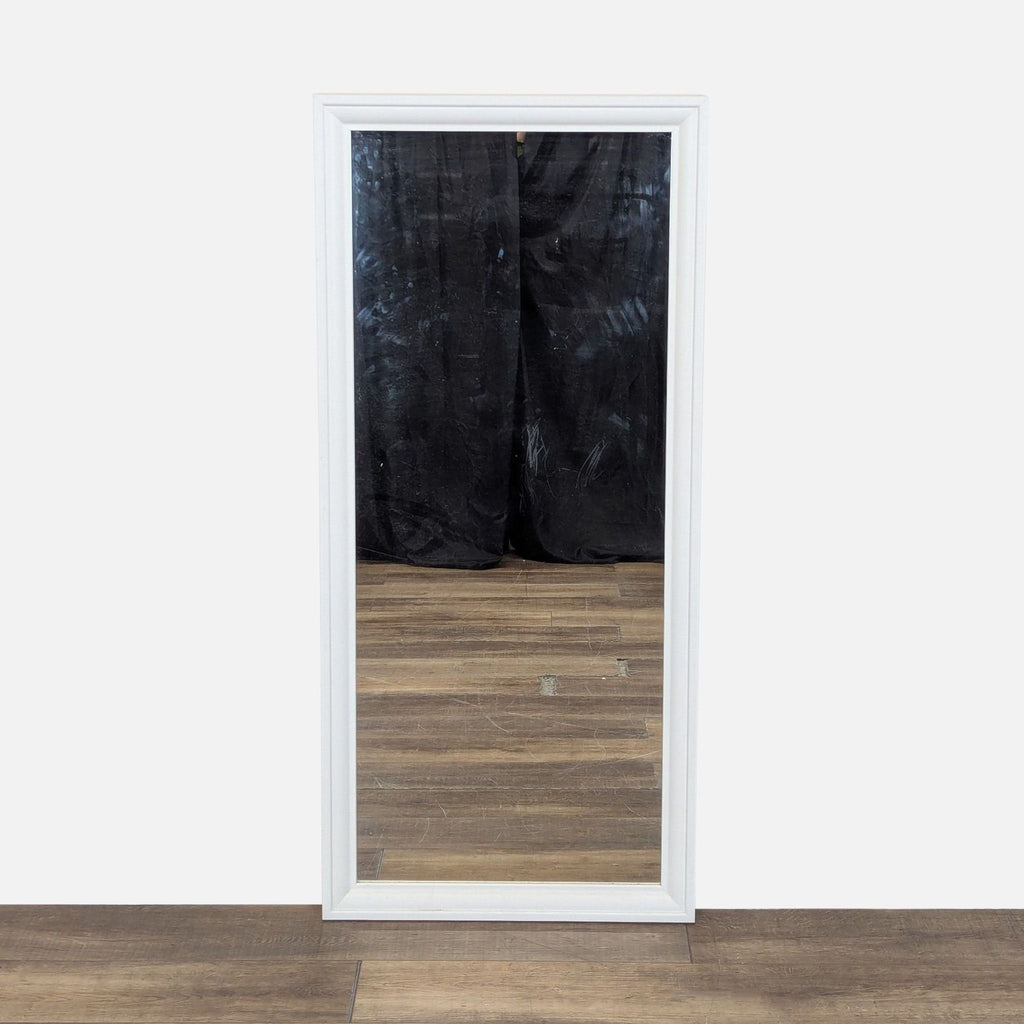 1. Rectangular Ikea mirror with a white frame, shown standing upright on a wooden floor with a black backdrop.