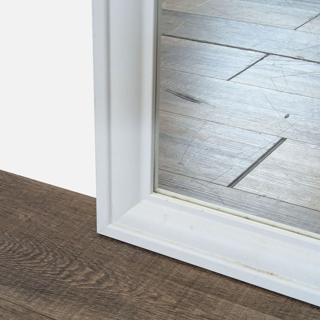 3. Close-up of the Ikea mirror’s corner, highlighting the white frame’s edge and reflective glass surface.