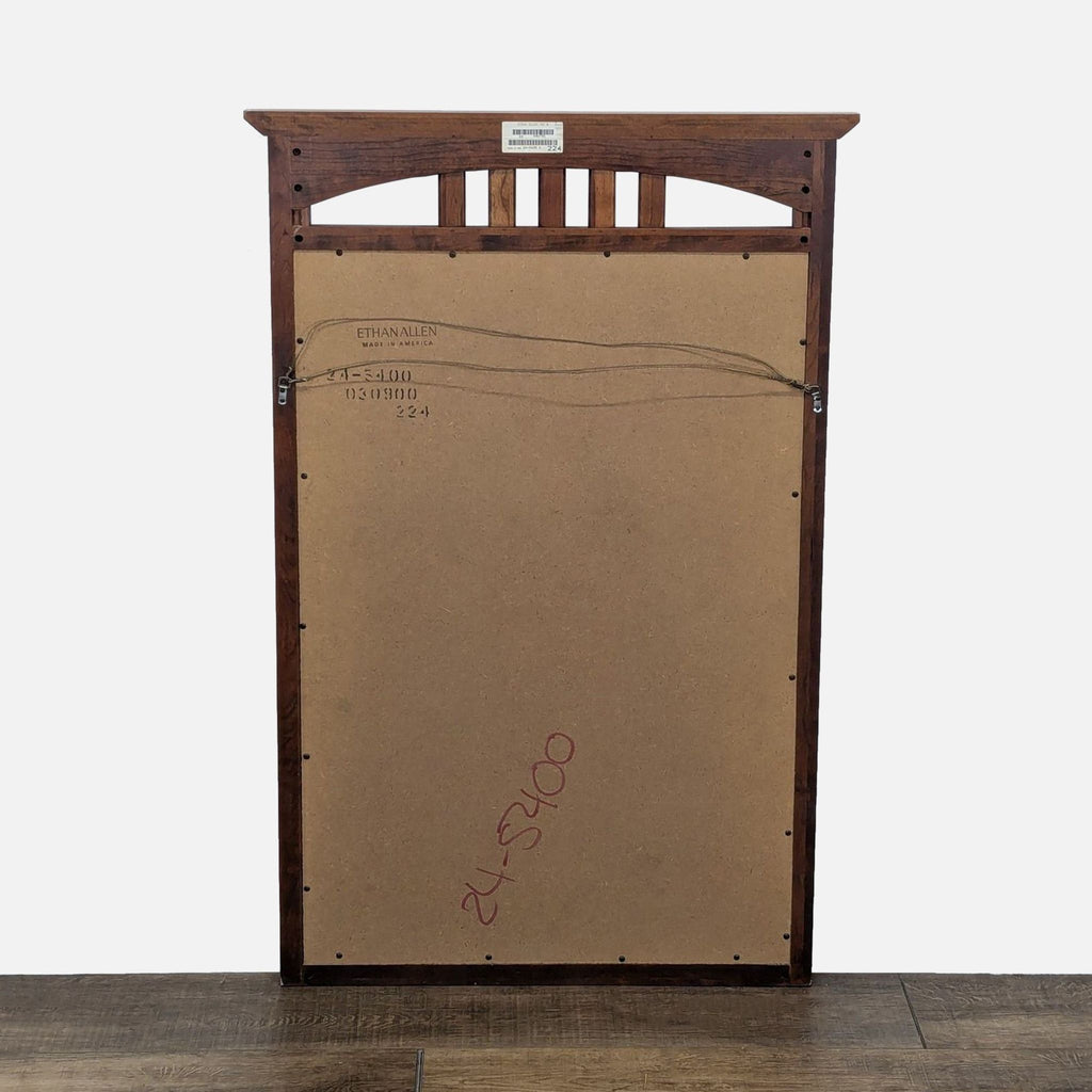 2. Back view of the Ethan Allen mirror, showing brown panel, hanging wire, and branded stamp.