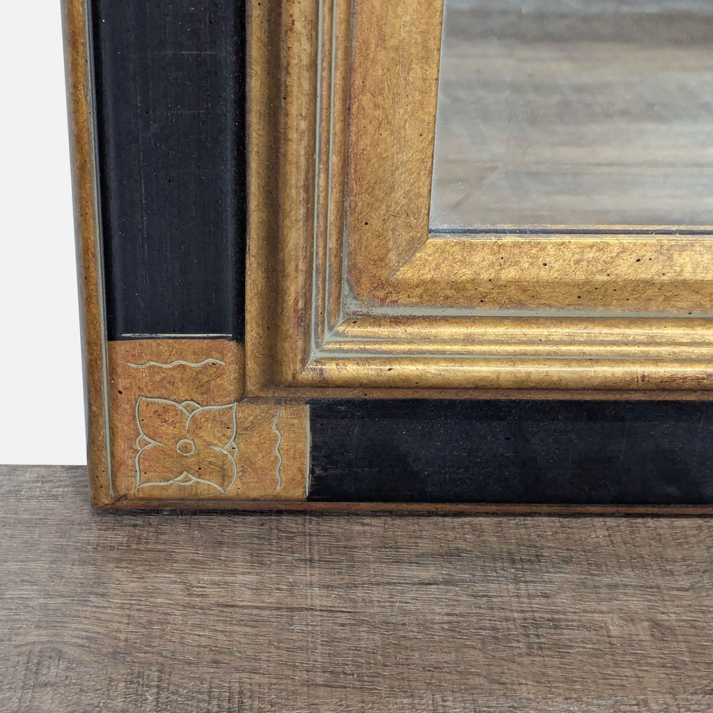2. Close-up of the Reperch mirror's corner, showing gold and black detailing with an engraved floral motif.