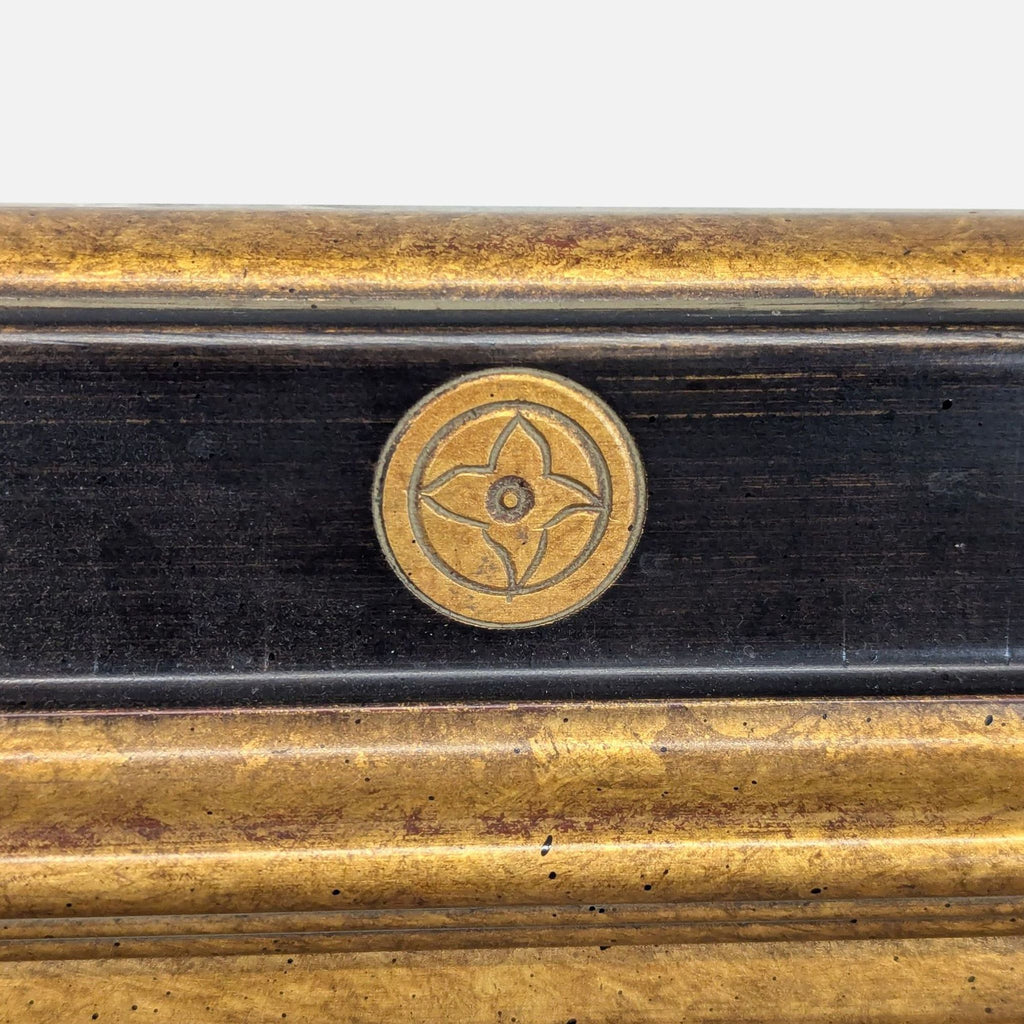 3. Detailed view of the Reperch mirror's frame highlighting a gold circular floral emblem on a black background.
