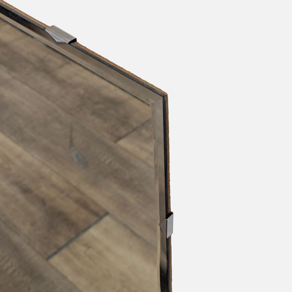 3. Close-up of the corner of the Reperch mirror, highlighting its beveled glass edge and metal clip.