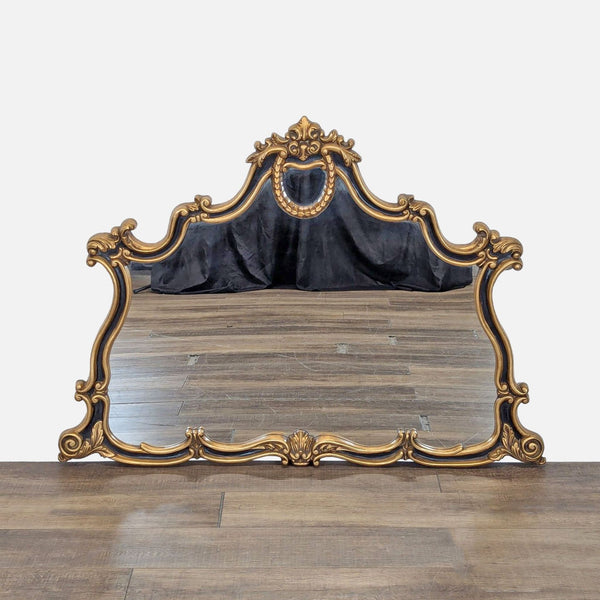1. Ornate Reperch mirror with arch over mantle shape and black and gold finish, featuring intricate details.