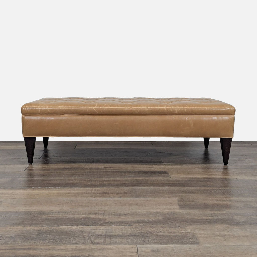 1. Rectangular tan leather ottoman with dark wood legs, tufted top, from West Elm on a wood floor.