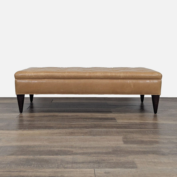 1. Rectangular tan leather ottoman with dark wood legs, tufted top, from West Elm on a wood floor.