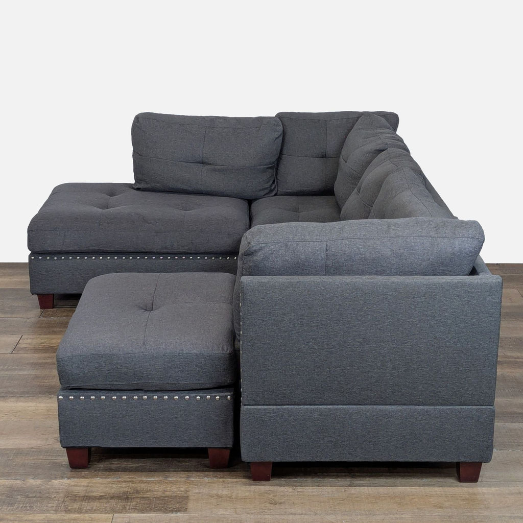 3. Back angle of gray studded sectional with ottoman, plush seat cushions, and reversible chaise design.