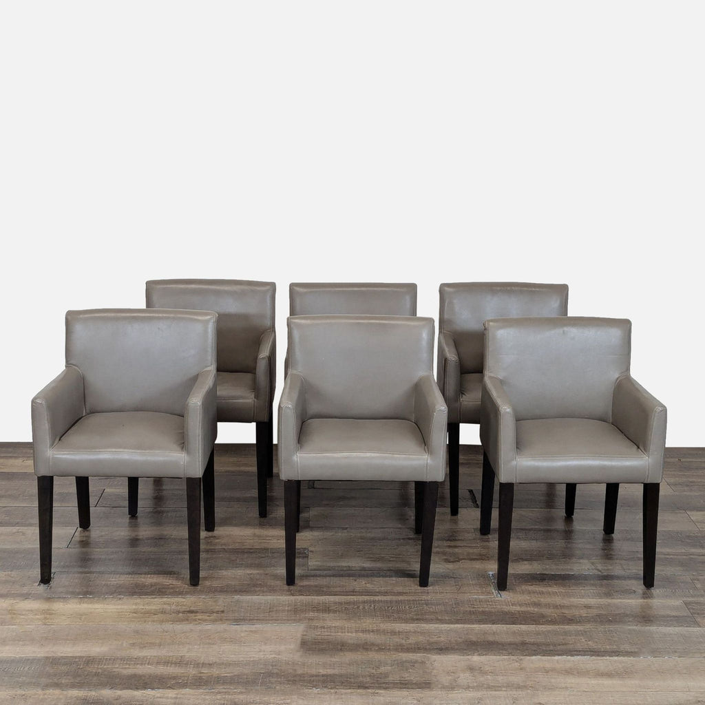 1. Set of six gray West Elm dining chairs with armrests, wooden legs, and modern design on a wooden floor.