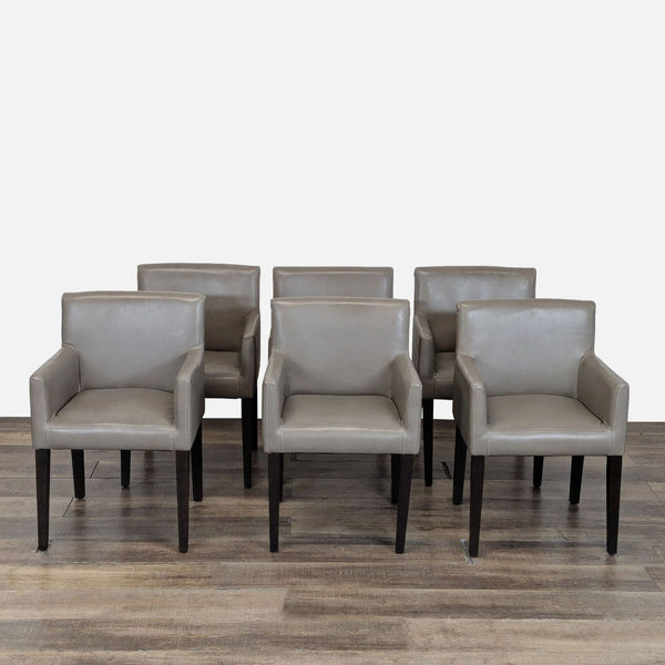 1. Set of six gray West Elm dining chairs with armrests, wooden legs, and modern design on a wooden floor.
