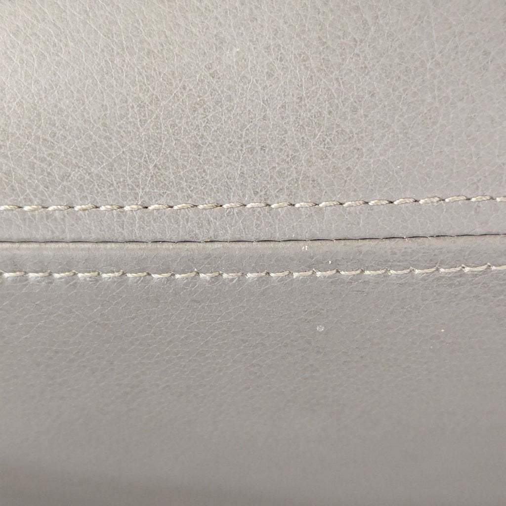 2. Close-up view of gray faux leather upholstery with double stitched seams on West Elm dining chair.