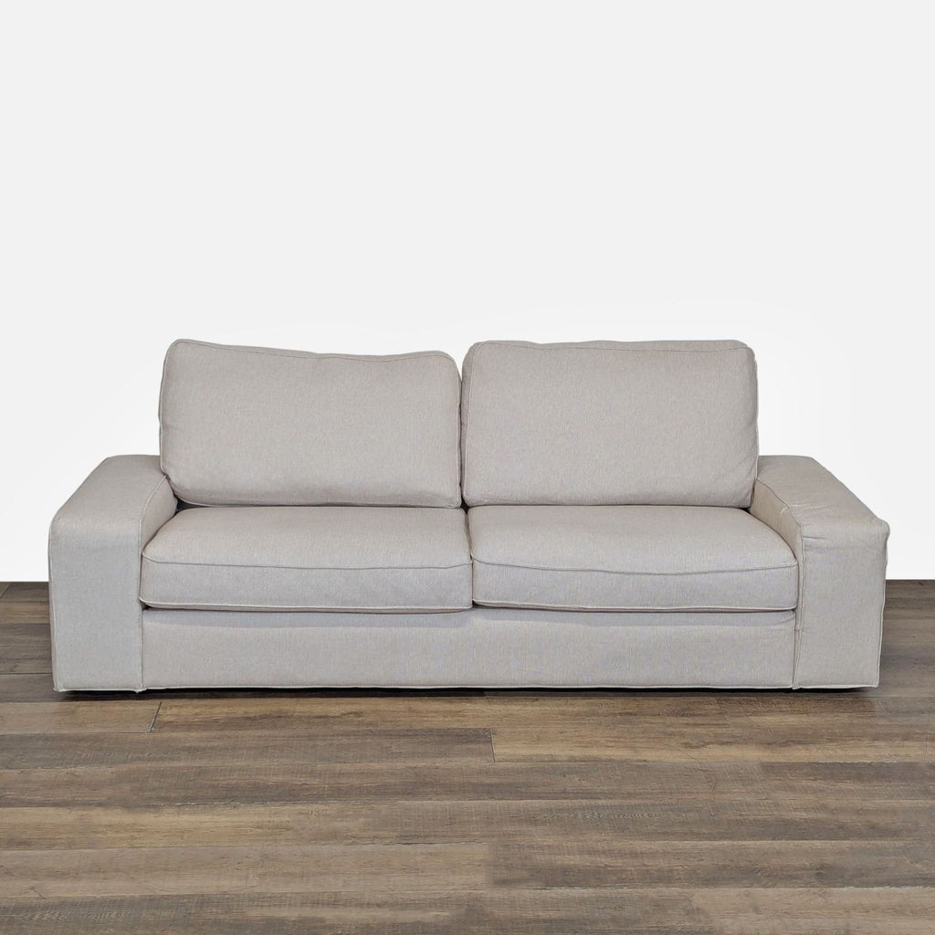 1. Front view of Ikea 3-seat sofa with wide cushions, low armrests, and body-adapting pocket spring foam.