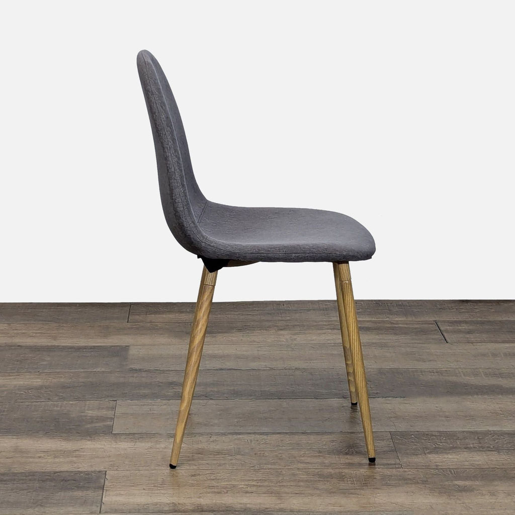 2. Side profile of a Reperch dining chair showing a sleek grey upholstered seat and slanted wooden legs.