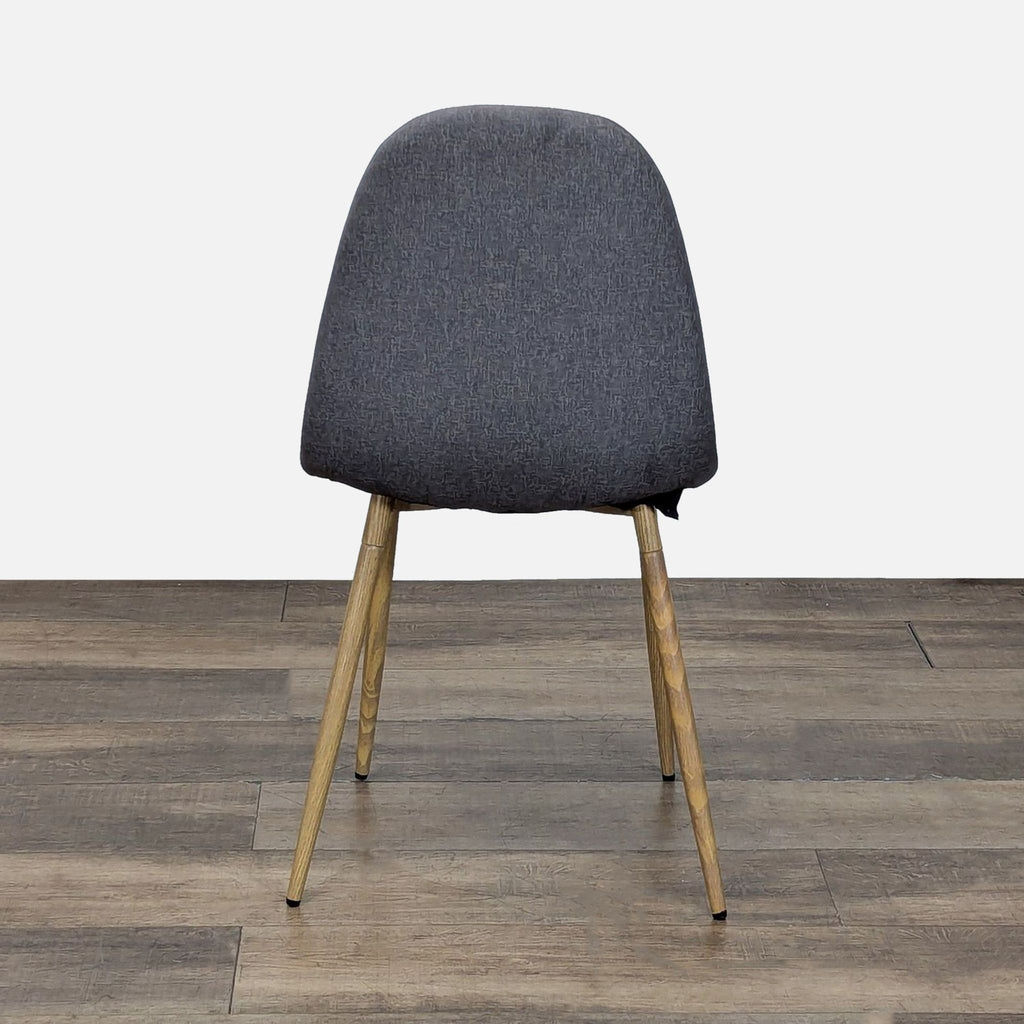 3. Rear view of a Reperch dining chair featuring a gently curved grey backrest and light wood-toned legs.