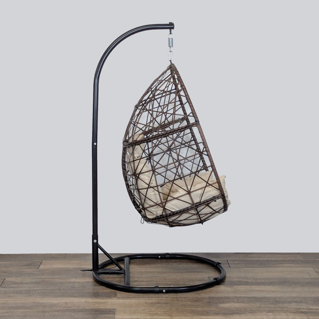2. Side view of Reperch woven egg chair on a sturdy black metal stand, featuring a plush weatherproof cushion.