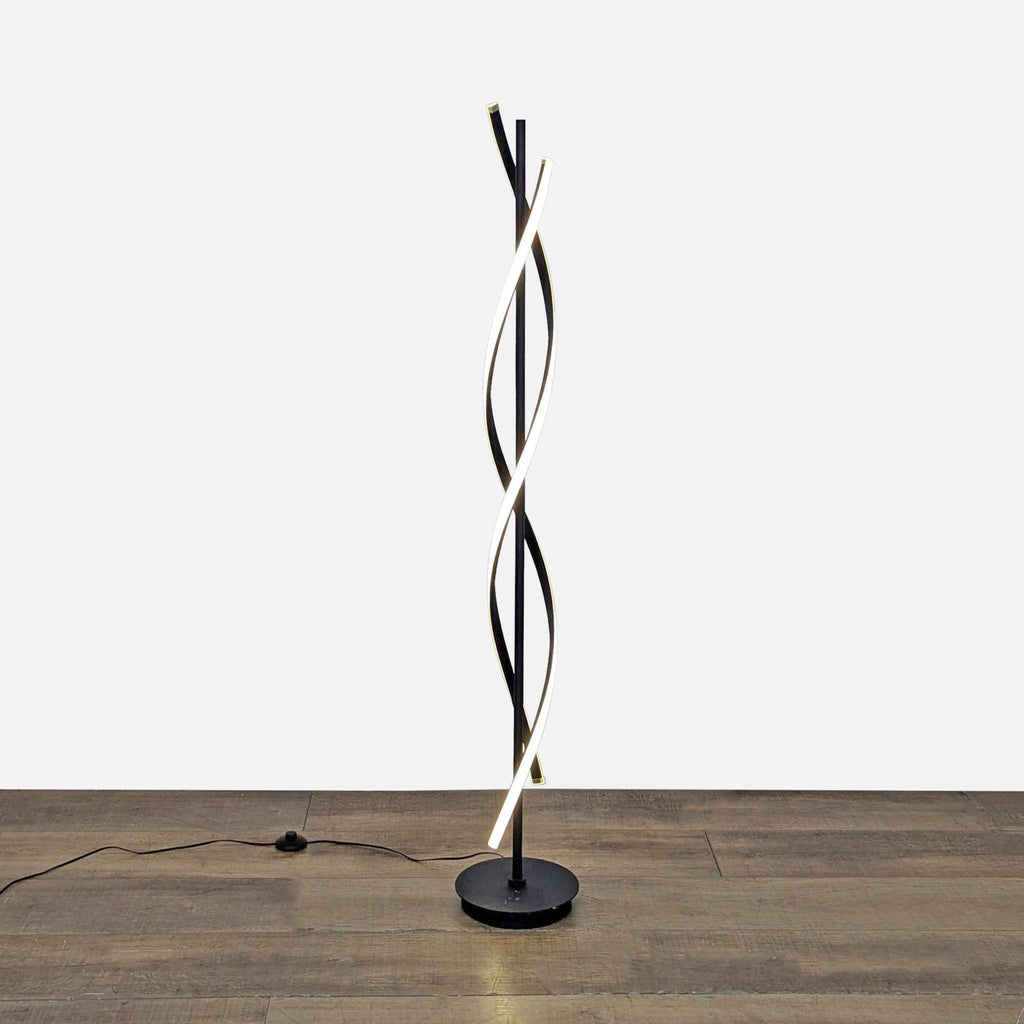Black metal spiral floor lamp with LED light, standing on a wooden floor, from Reperch Lighting.  