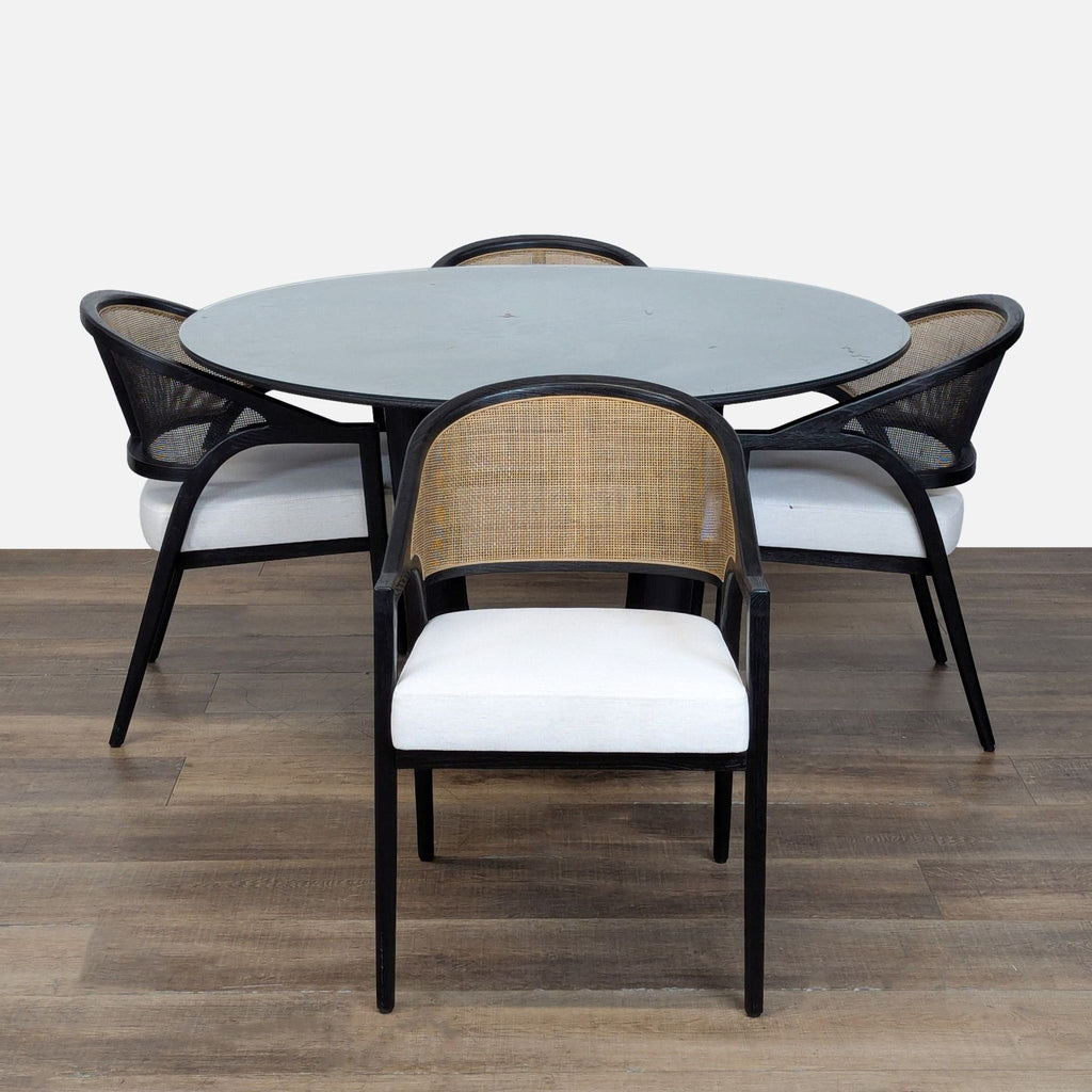 1. Arhaus dining set with round wood table, glass top, and four Aimee Armchairs with rattan, curved backs.