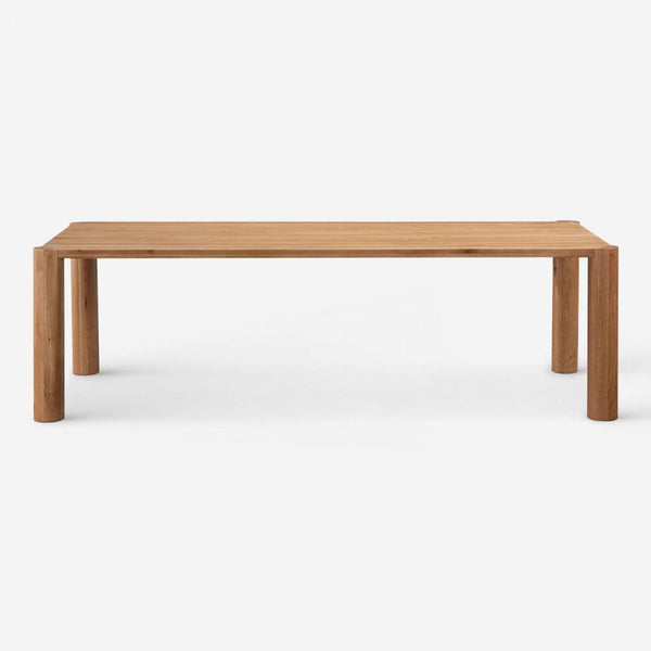 Front view of a Lulu and Georgia oak dining table with round legs attachable at varied angles for customizable style.