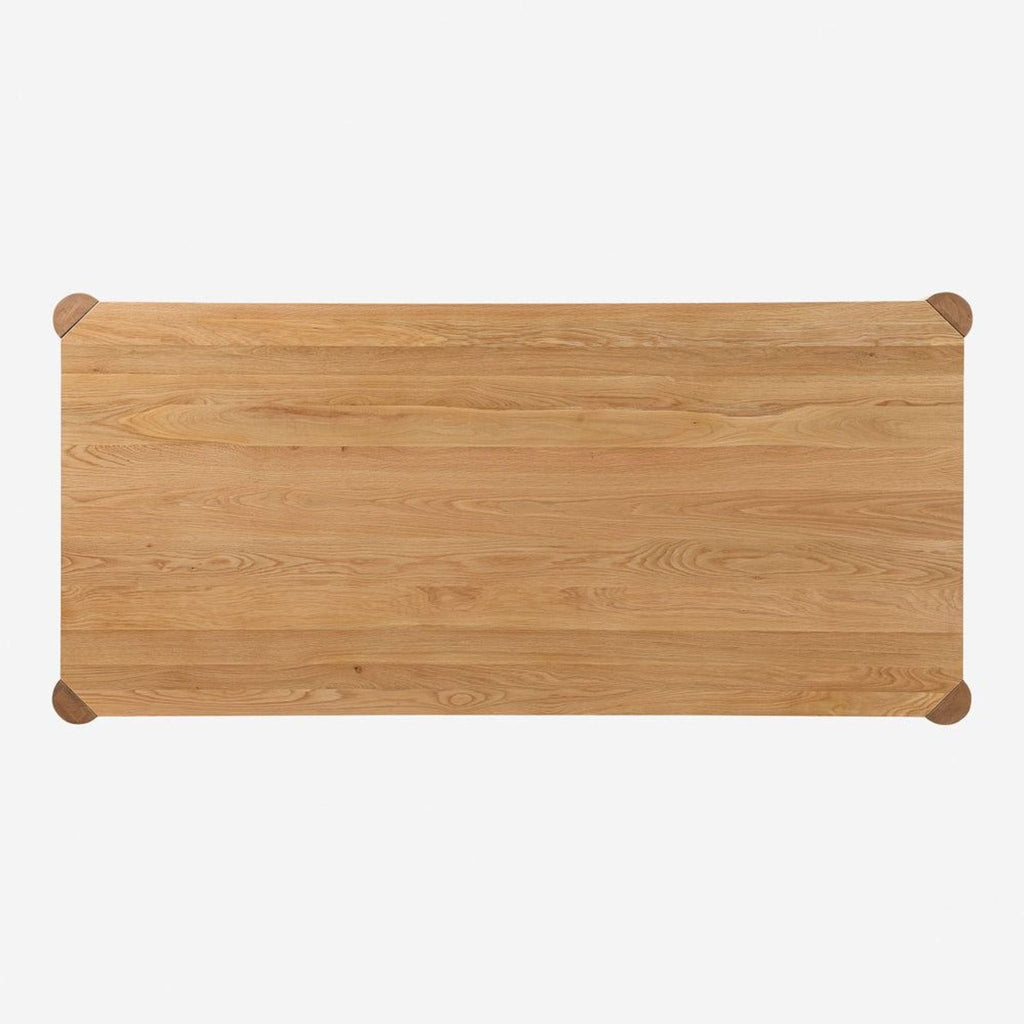 Top-down view of a Lulu and Georgia oak dining table, highlighting its rectangular surface and unique adjustable leg corners.