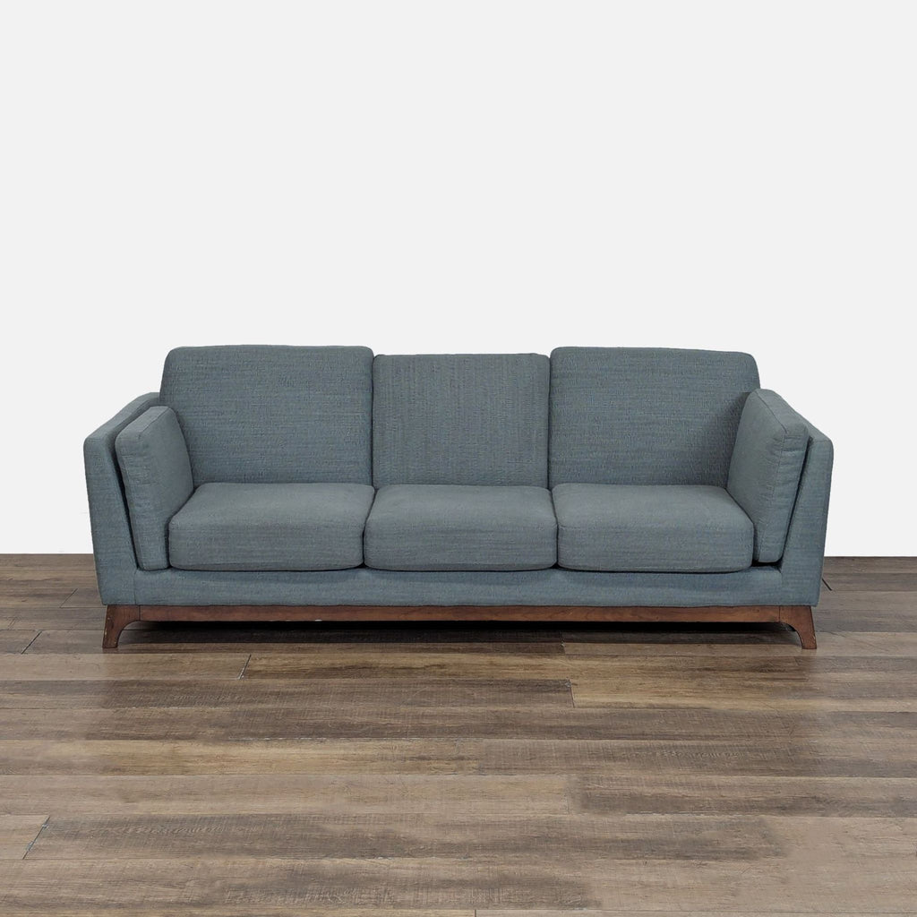1. Front view of an Article 3-seat sofa with loose cushions, track arm rests, and a solid wood base.