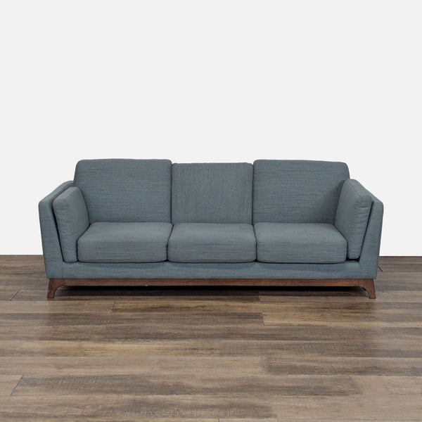 1. Front view of an Article 3-seat sofa with loose cushions, track arm rests, and a solid wood base.
