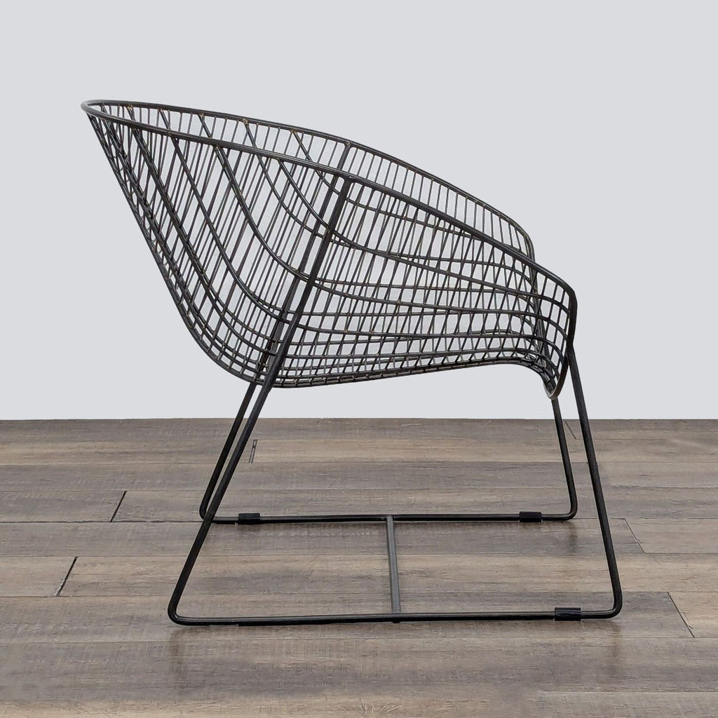 2. CB2 black iron lounge chair with curved wire frame, perfect for contemporary living spaces, made in India.