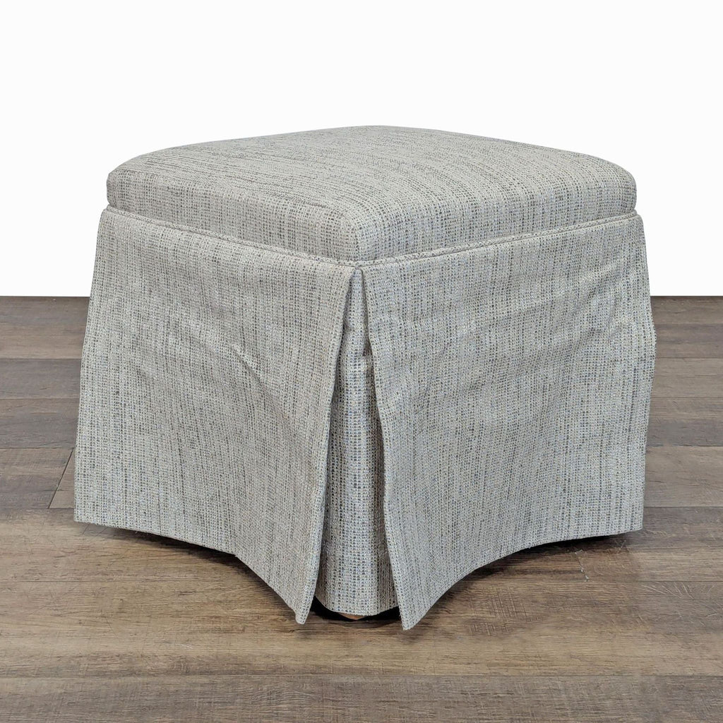 1. Light grey Reperch ottoman with textured fabric and skirted sides, shown on a wooden floor.