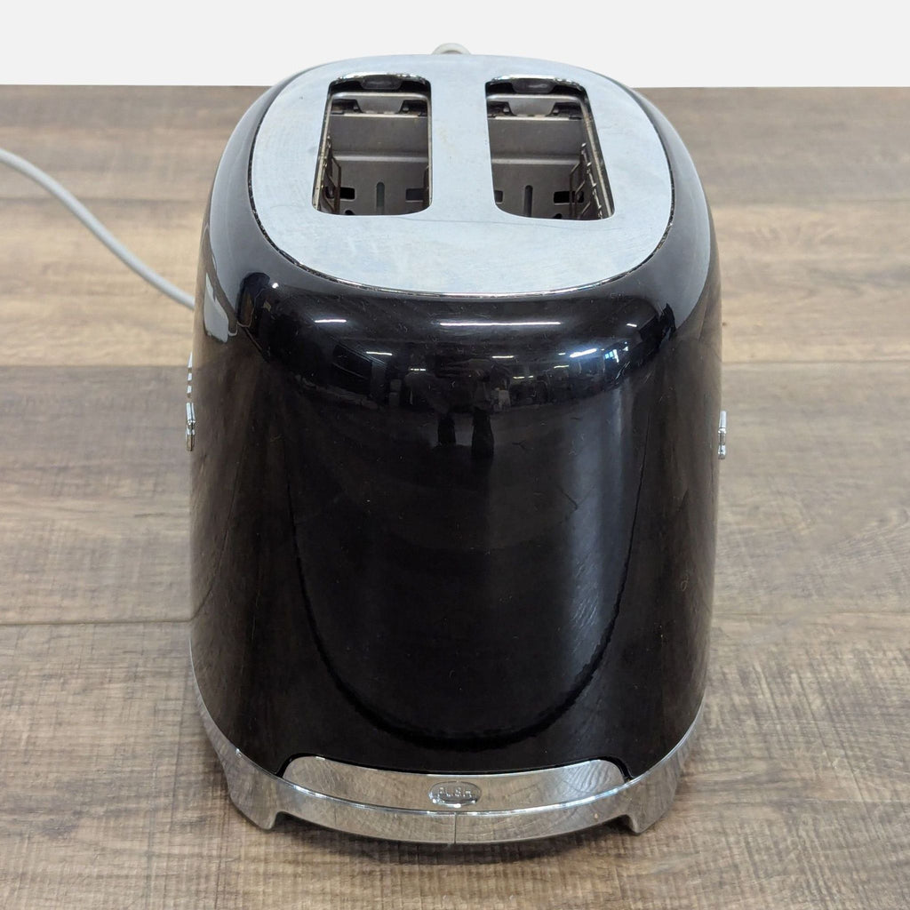 3. Top-down rear view of the Smeg black toaster, highlighting its dual slots and rounded vintage style.