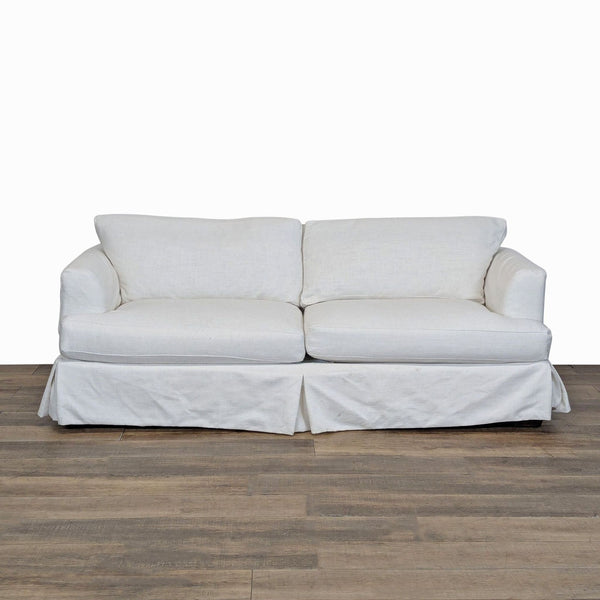 1. Joss & Main 3-seat sofa with wood frame, tailored dressmaker skirt, and soft slipcovered cushions, front view.