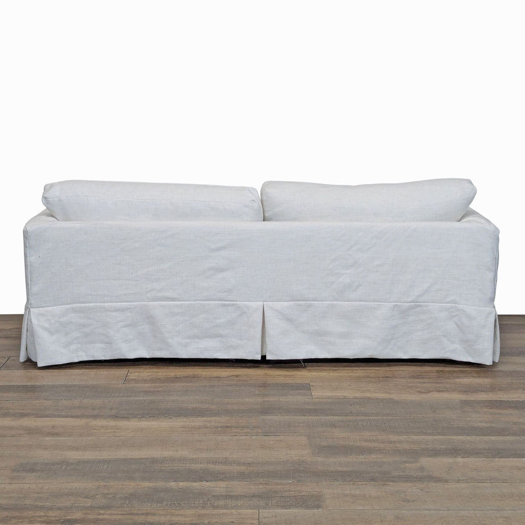 3. Rear view of Joss & Main 3-seat sofa, displaying its dressmaker-style skirt and neatly slipcovered design.