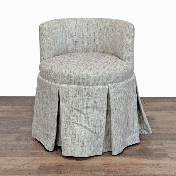1. Custom chair with rounded back, light textured upholstery, and a box-pleated skirt hiding wood casters.  