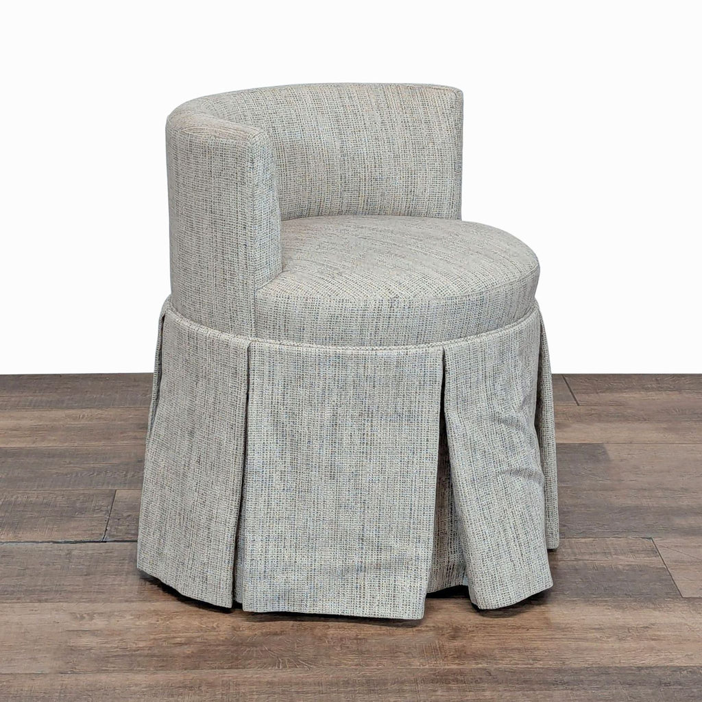 2. Side view of a Reperch chair in neutral fabric, featuring a rounded backrest and pleated skirt over wheels.  