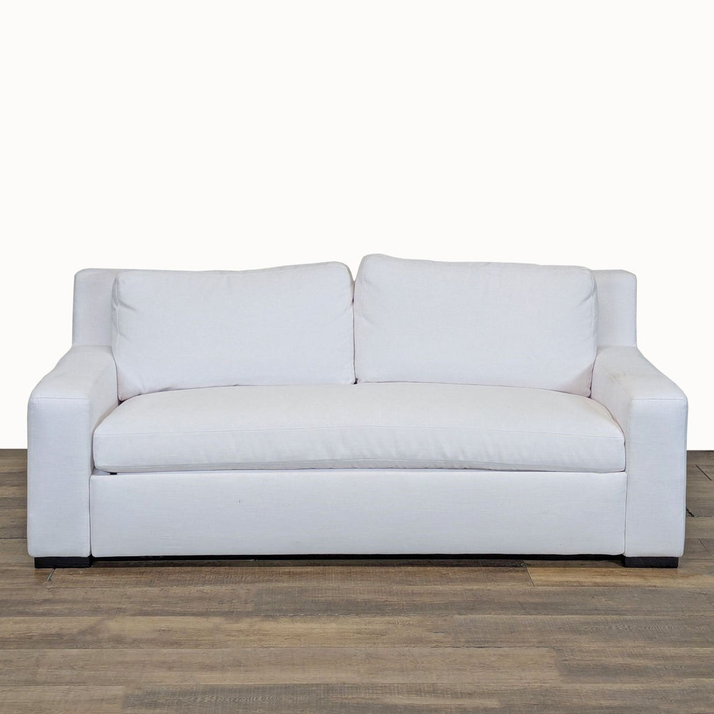 1. Front view of a white Restoration Hardware sleeper sofa with fabric upholstery and track arms on wood floor.