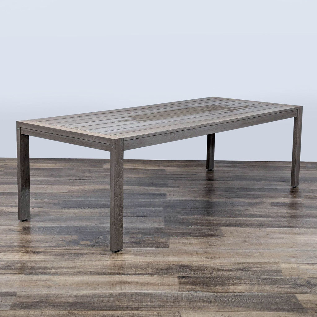 3. Angled view of a weathered teak plank table by Restoration Hardware, modern and minimalist, on wood floor.