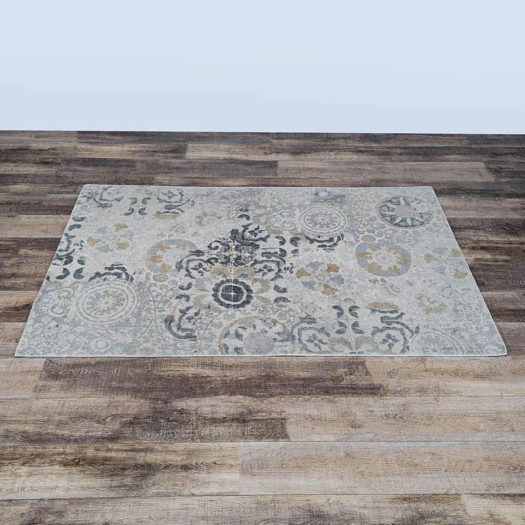 1. Pottery Barn rug with a vintage-inspired pattern, displayed on a wood floor. Soft neutral and blue tones.