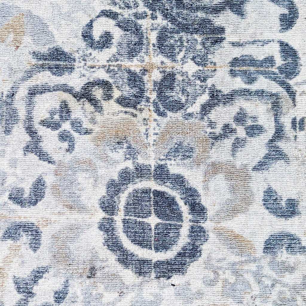 2. Detailed closeup of Pottery Barn wool rug shows intricate, high-low pile pattern in blue and beige hues.