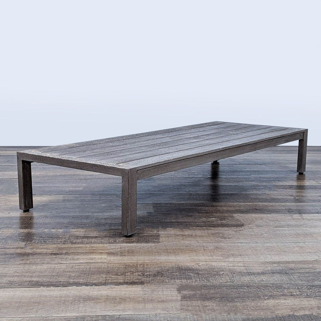 3. Angled shot of a Restoration Hardware table featuring solid weathered teak construction and plank-style top.