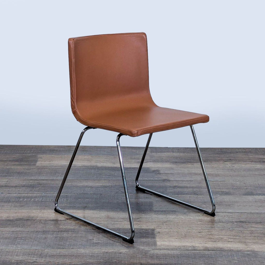 2. Angled view of the Ikea Bernhard Dining Chair showing brown leather padding and sleek chrome legs, by Ola Wihlborg.