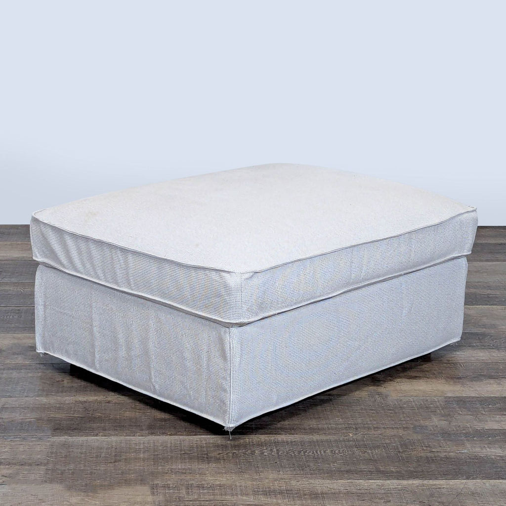 1. Light gray Ikea ottoman with a soft cushion top, shown on a wooden floor, closed and ready for seating.  