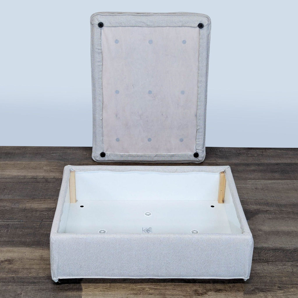 2. Ikea ottoman with lid removed, revealing a spacious interior storage compartment, placed on wood flooring.  