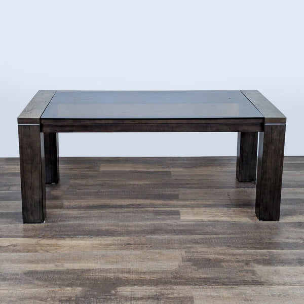1. Contemporary gray dining table with thick smoked glass top, wide legs, and metal accent bands by Ashley.