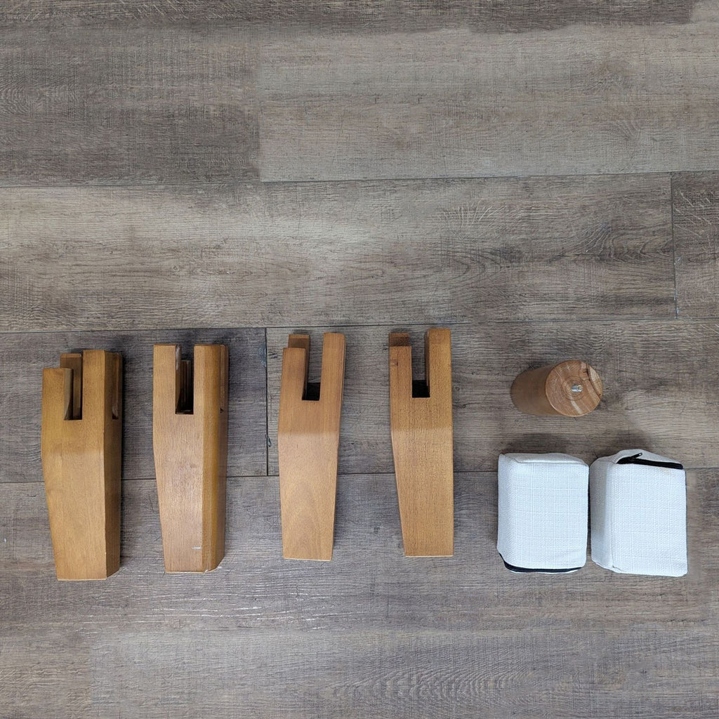 2. Four Thuma wooden frame legs and assembly components arranged on a wood floor, ready for setup.  